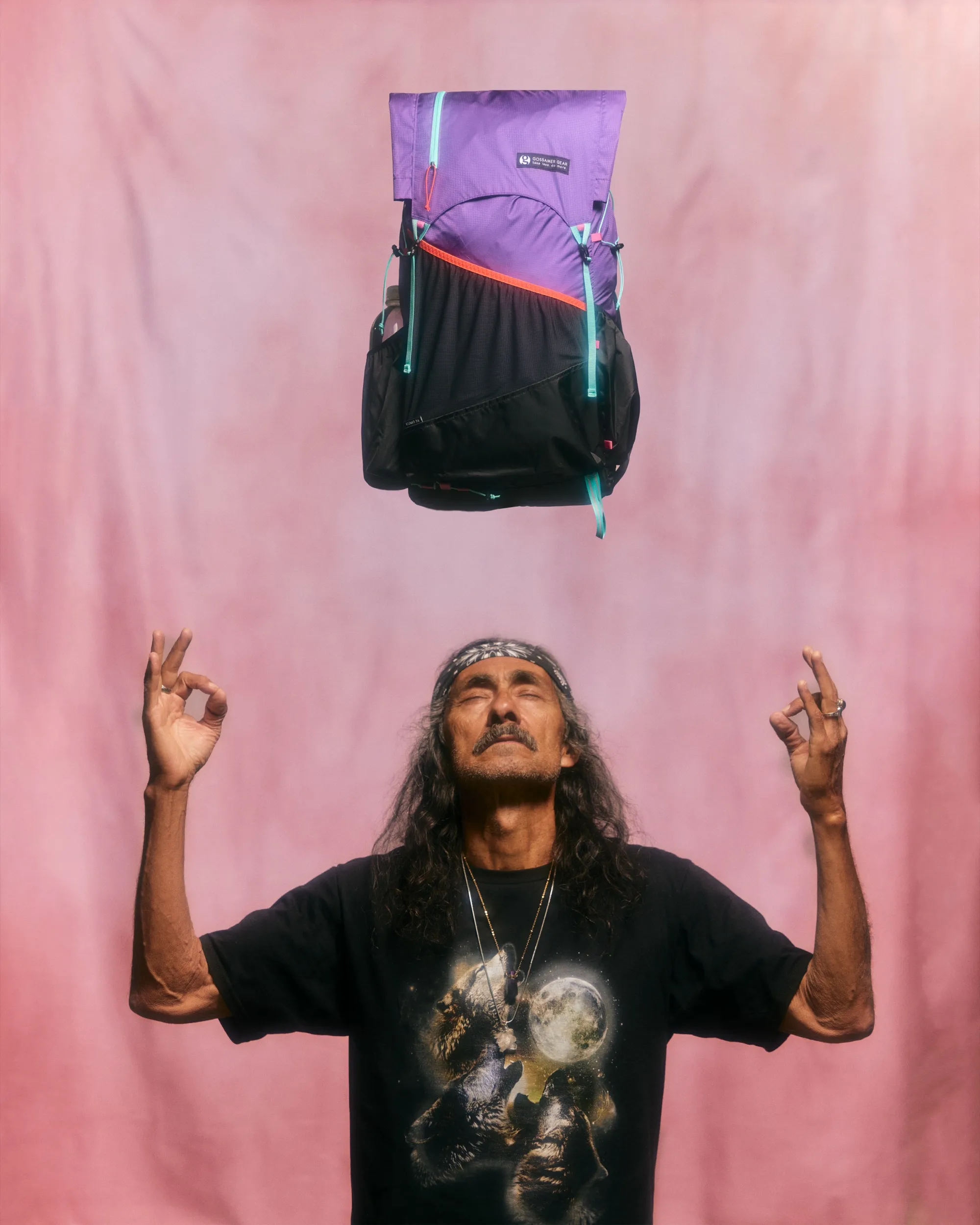 Purple Kumo 36 pack floating above a man with raised hands against a pink backdrop